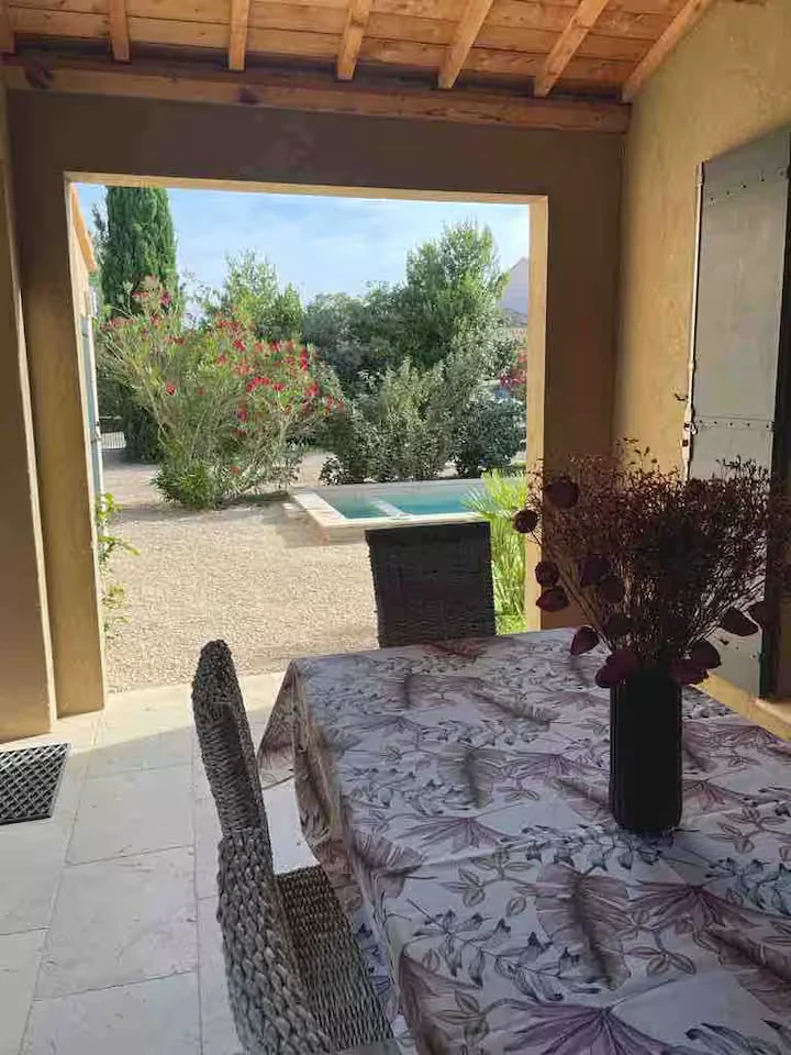 Terrasse couverte avec coin repas extérieur et vue sur le jardin à Saint-Rémy-de-Provence